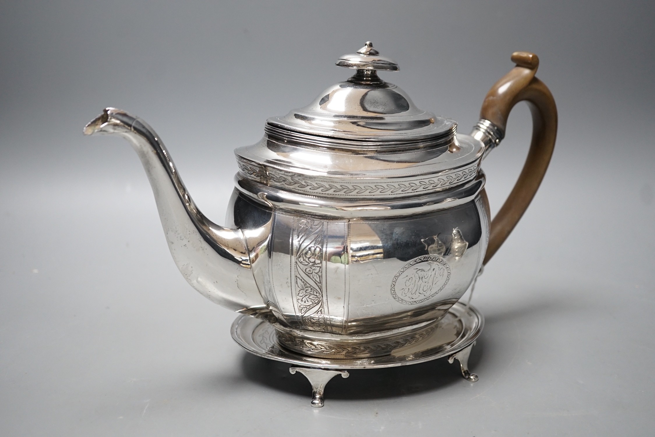 A George III engraved silver oval teapot, Alice & George Burroughs?, London, 1804 and an associated oval silver stand, James Darquits, London, 1805, gross weight 18.3oz.